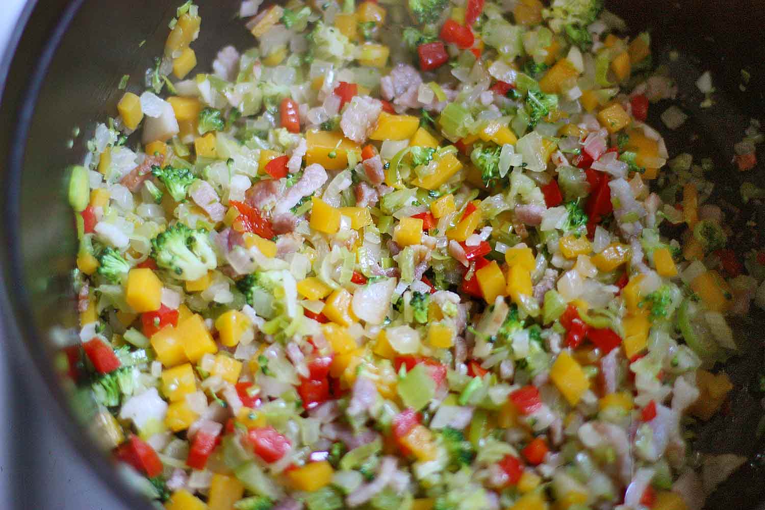 Chopped vegetables cooking in a soup pot.