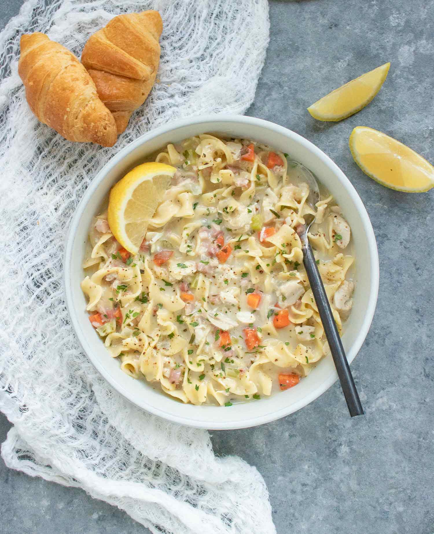Overhead shot of Creamy Chicken Noodle Soup in a bowl with a spoon.