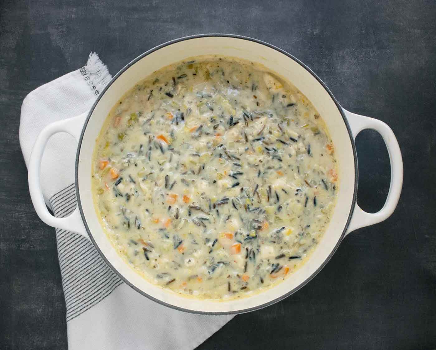 Overhead view of Creamy Chicken Wild Rice Soup in a large white Dutch oven.