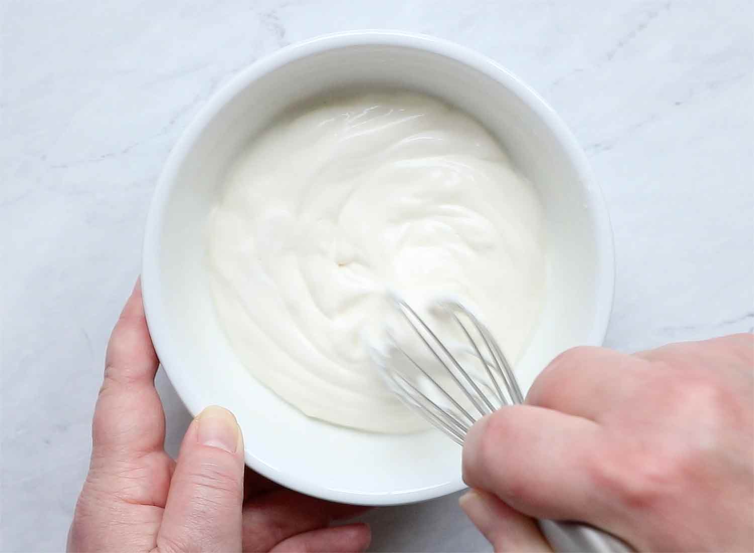 Step 1: whisking the sour cream and mayo in a bowl.