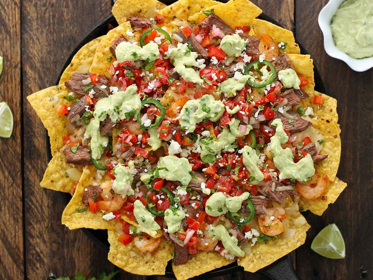 Grilled Surf 'n Turf Nachos on a cast iron serving try.