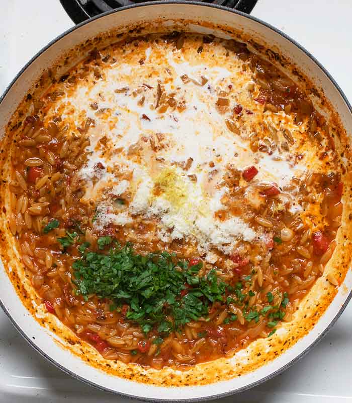 Adding cream, cheese, parsley and lemon zest to finish the sauce.