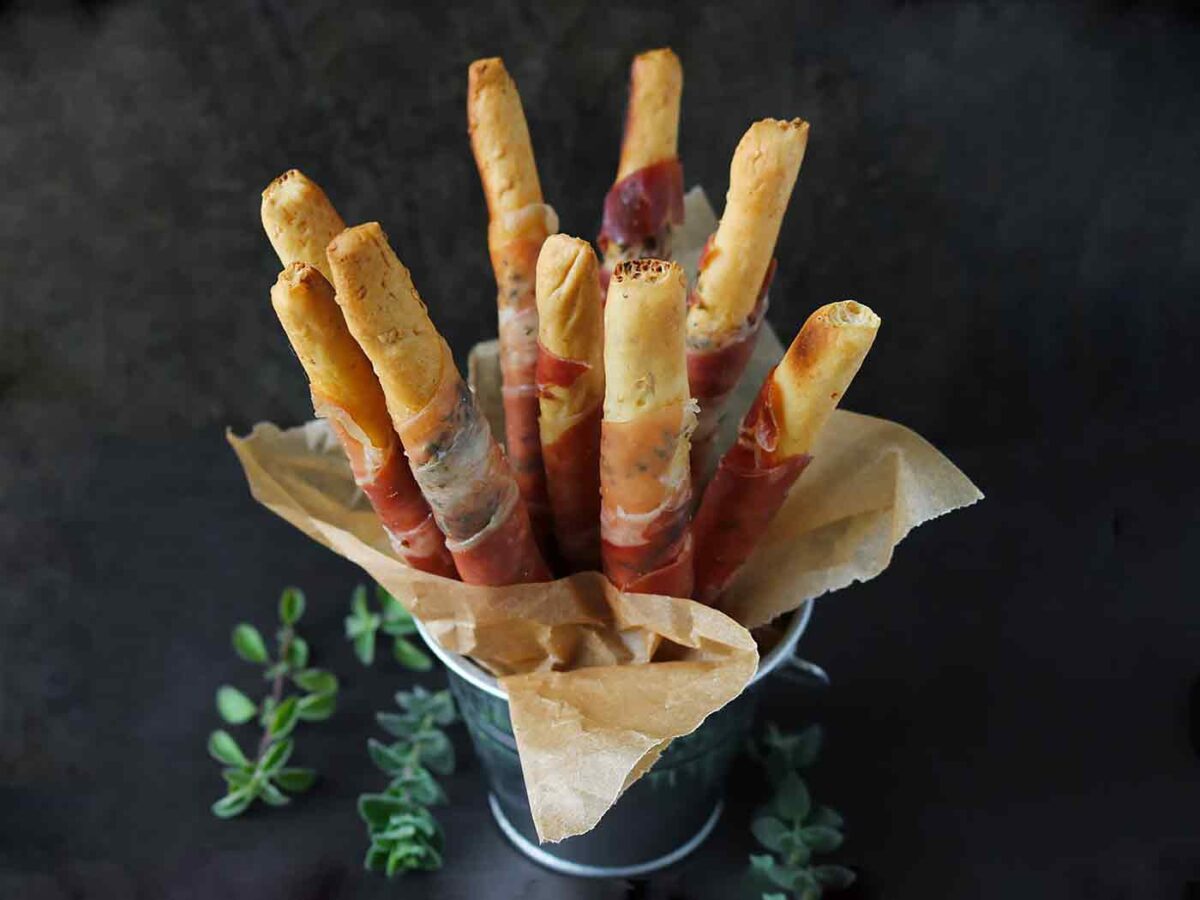 Prosciutto-wrapped Breadsticks in a serving tin.