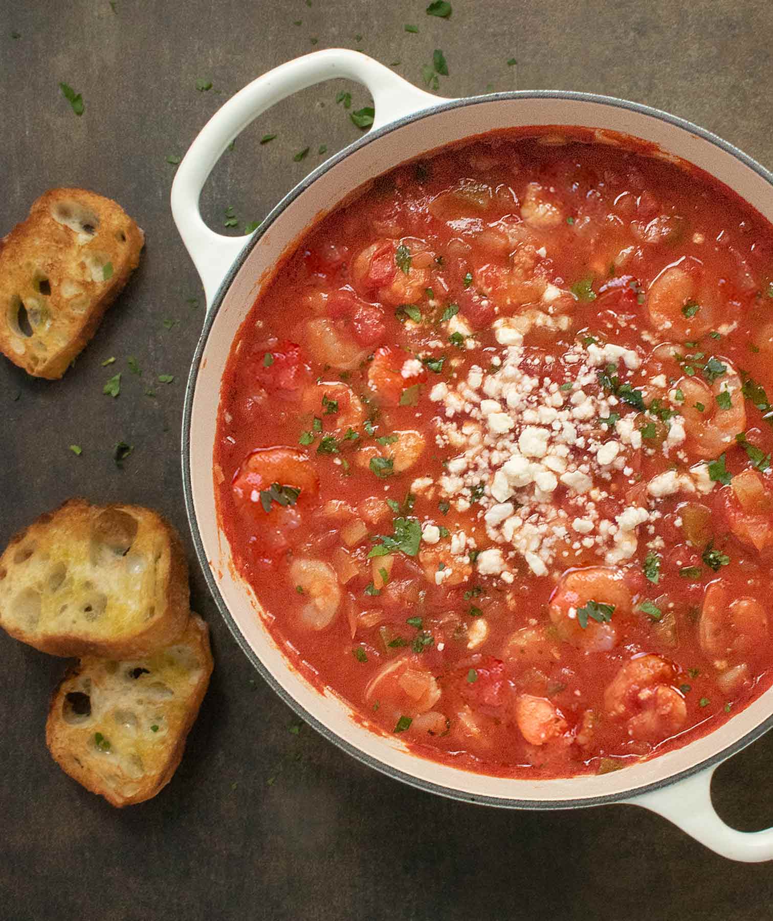 Overhead view of the soup in a soup pot with a side of toasted bread.